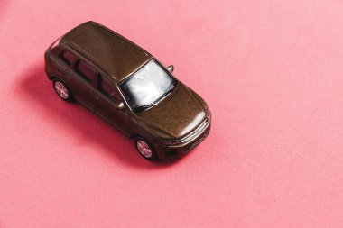 Pembe bir arka plan üzerinde bir çikolata oyuncak araba.