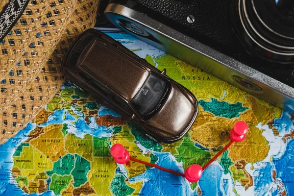 Autóipari utazási cél pontot a világ Térkép jelzett színes rajzszeget, a kötél és a sekély mélységélesség. — Stock Fotó