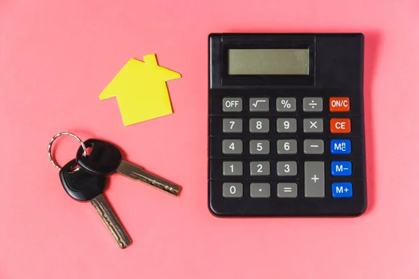 Mortgage Loans Concept with Key, Paper House and Calculator on Pink Background.