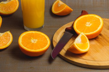 Ahşap kesme tahtası üzerinde bıçakla dilimlenmiş portakal. Organik meyve koyu arka plan üzerinde. Sağlıklı kavramı.