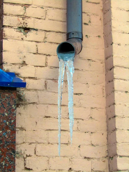 Winter icicles hanging from a drainpipe. photo — Stock Photo, Image