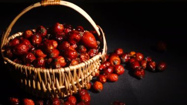 Hasır sepetteki gül kalçalarının makro görünümü. Latince Fructus cynosbati. Kurumuş gül kalçası alternatif tıpta önemli bir vitamin kaynağıdır..