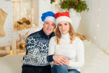 Güzel, genç ve aşık bir çift Noel arkaplanında eğleniyor..