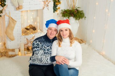 Güzel, genç ve aşık bir çift Noel arkaplanında eğleniyor..