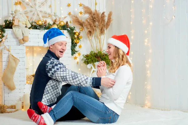 Piękna młoda para w miłości bawić się na tle Bożego Narodzenia. — Zdjęcie stockowe