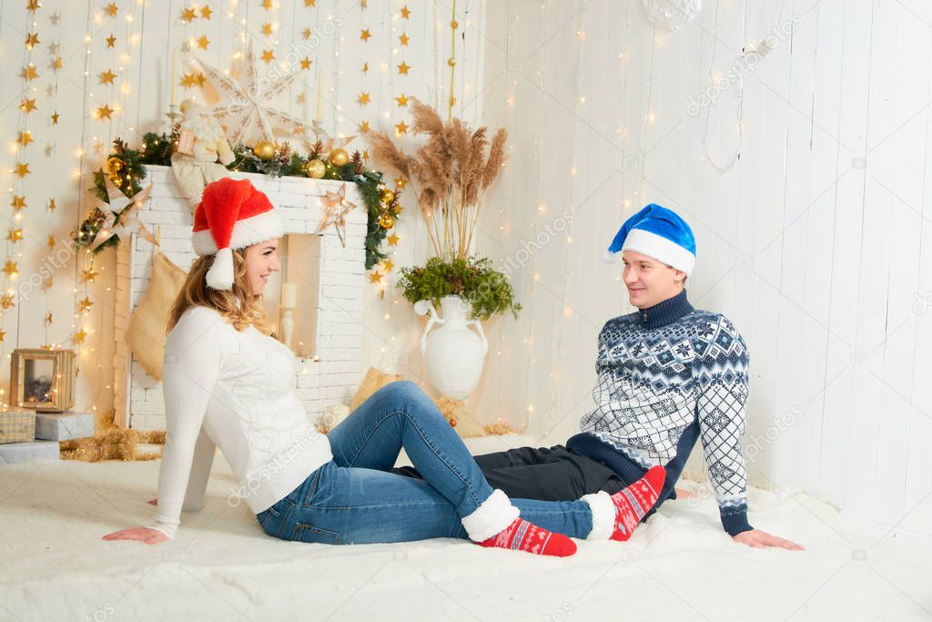 Beautiful young couple in love have fun on Christmas background.