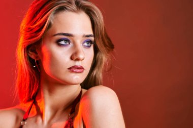 Güzel genç bir kadın portreye bakıyor. Temiz ciltli, model bir kız..