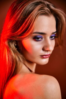 Güzel genç bir kadın portreye bakıyor. Temiz ciltli, model bir kız..