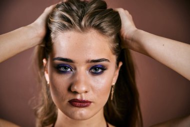 Güzel genç bir kadın portreye bakıyor. Temiz ciltli, model bir kız..