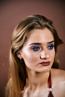 Güzel genç bir kadın portreye bakıyor. Temiz ciltli, model bir kız..