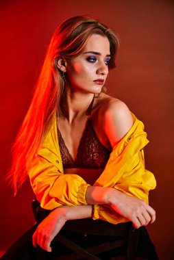 Güzel genç bir kadın portreye bakıyor. Temiz ciltli, model bir kız..