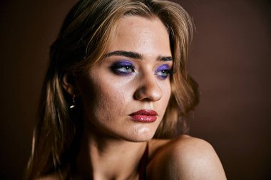 Güzel genç bir kadın portreye bakıyor. Temiz ciltli, model bir kız..