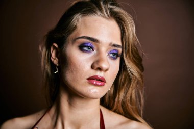 Güzel genç bir kadın portreye bakıyor. Temiz ciltli, model bir kız..