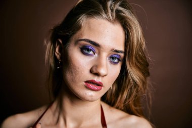 Güzel genç bir kadın portreye bakıyor. Temiz ciltli, model bir kız..