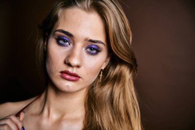 Güzel genç bir kadın portreye bakıyor. Temiz ciltli, model bir kız..