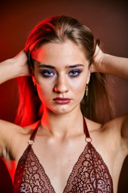 Güzel genç bir kadın portreye bakıyor. Temiz ciltli, model bir kız..