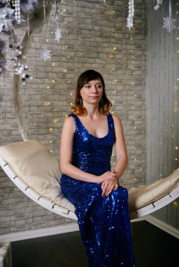 Genç, sıradan bir kadın. Mavi kokteyl elbisesi giymiş genç bir kadın..