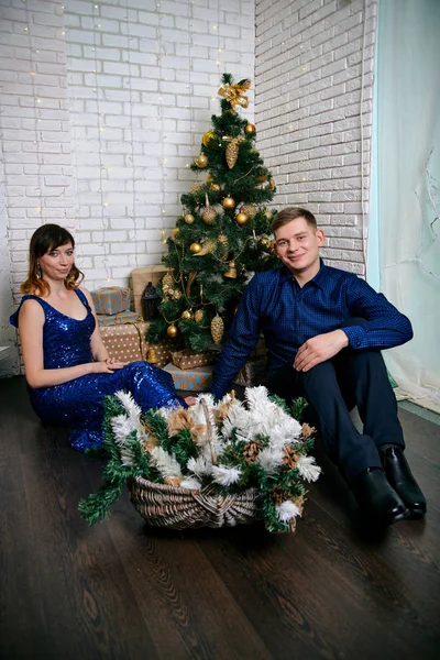 Jonge gewone familie van twee. Jonge man en vrouw in de buurt van kerstboom. Gelukkig jong hetero paar versieren kerstboom thuis. — Stockfoto