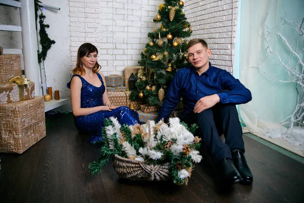 Jonge gewone familie van twee. Jonge man en vrouw in de buurt van kerstboom. Gelukkig jong hetero paar versieren kerstboom thuis. — Stockfoto