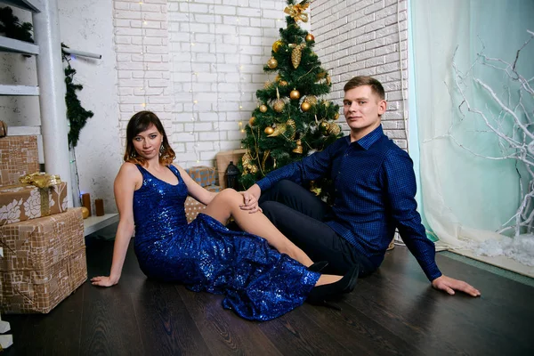 Jovem família comum de dois. Jovem marido e mulher perto da árvore de Natal. Jovem feliz casal hetero decorar árvore de Natal em casa . — Fotografia de Stock
