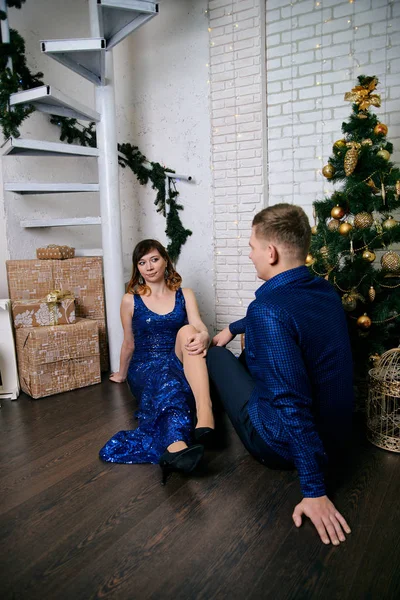 Young ordinary family of two. Young husband and wife near christmas tree. Happy young hetero couple decorate christmas tree at home. — Stock Photo, Image