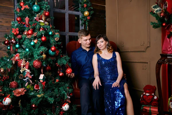 Jovem família comum de dois. Jovem marido e mulher perto da árvore de Natal. Jovem feliz casal hetero decorar árvore de Natal em casa . — Fotografia de Stock