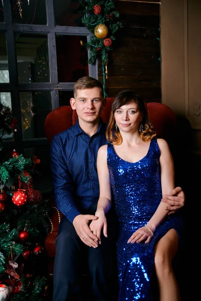 Young ordinary family of two. Young husband and wife near christmas tree. Happy young hetero couple decorate christmas tree at home. — 스톡 사진