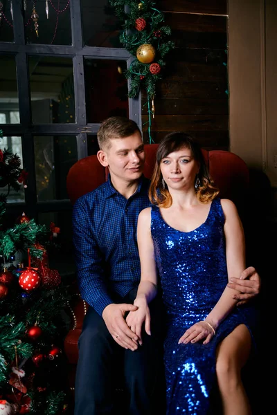 Young ordinary family of two. Young husband and wife near christmas tree. Happy young hetero couple decorate christmas tree at home. — 스톡 사진