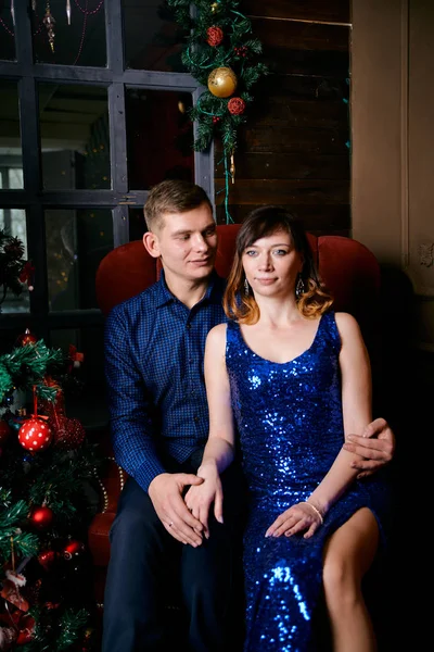 Young ordinary family of two. Young husband and wife near christmas tree. Happy young hetero couple decorate christmas tree at home. — 스톡 사진