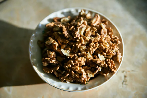 A dish full of peeled kernels of walnut closeup top view. — Stock Photo, Image