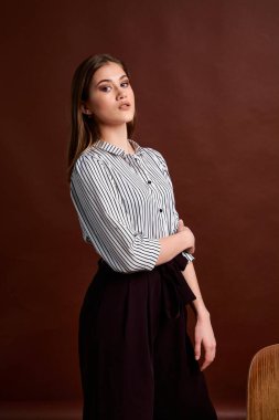 Genç bağımsız kadının mininalizm stili klasik stüdyo fotoğraf seti. Klasik takım elbiseli, siyah ayakkabılı ve gri ceketli güzel bir bayan. Klasik sandalye. Kadın kıyafetleri. Şık kıyafetler..