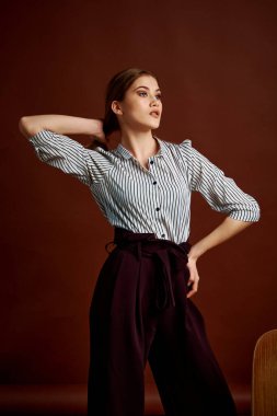 Genç bağımsız kadının mininalizm stili klasik stüdyo fotoğraf seti. Klasik takım elbiseli, siyah ayakkabılı ve gri ceketli güzel bir bayan. Klasik sandalye. Kadın kıyafetleri. Şık kıyafetler..