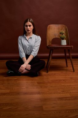 Genç bağımsız kadının mininalizm stili klasik stüdyo fotoğraf seti. Klasik takım elbiseli, siyah ayakkabılı ve gri ceketli güzel bir bayan. Klasik sandalye. Kadın kıyafetleri. Şık kıyafetler..