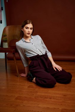 Genç bağımsız kadının mininalizm stili klasik stüdyo fotoğraf seti. Klasik takım elbiseli, siyah ayakkabılı ve gri ceketli güzel bir bayan. Klasik sandalye. Kadın kıyafetleri. Şık kıyafetler..