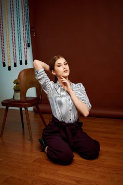 Genç bağımsız kadının minimalizm stili klasik stüdyo fotoğraf seti. Klasik takım elbiseli, siyah ayakkabılı ve gri ceketli güzel bir bayan. Klasik sandalye. Kadın kıyafetleri. Şık kıyafetler..