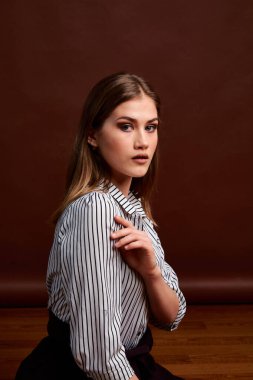 Genç bağımsız kadının minimalizm stili klasik stüdyo fotoğraf seti. Klasik takım elbiseli, siyah ayakkabılı ve gri ceketli güzel bir bayan. Klasik sandalye. Kadın kıyafetleri. Şık kıyafetler..