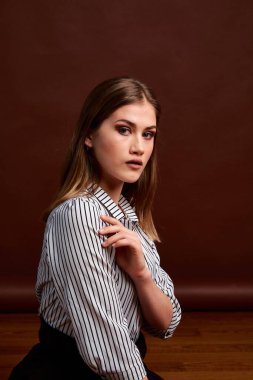 Genç bağımsız kadının minimalizm stili klasik stüdyo fotoğraf seti. Klasik takım elbiseli, siyah ayakkabılı ve gri ceketli güzel bir bayan. Klasik sandalye. Kadın kıyafetleri. Şık kıyafetler..