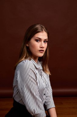 Genç bağımsız kadının minimalizm stili klasik stüdyo fotoğraf seti. Klasik takım elbiseli, siyah ayakkabılı ve gri ceketli güzel bir bayan. Klasik sandalye. Kadın kıyafetleri. Şık kıyafetler..