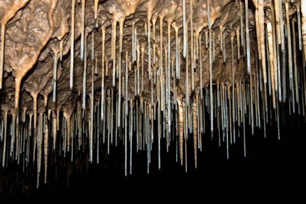 stock image thin stalactites in a cave