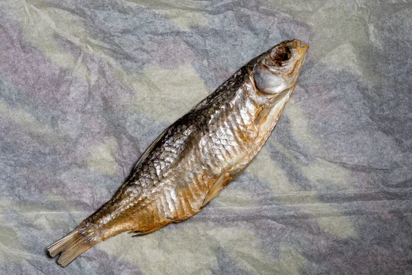 Torkad fisk på gammalt skrynkligt papper. Öl mellanmål. Högsta tittarsiffror. — Stockfoto
