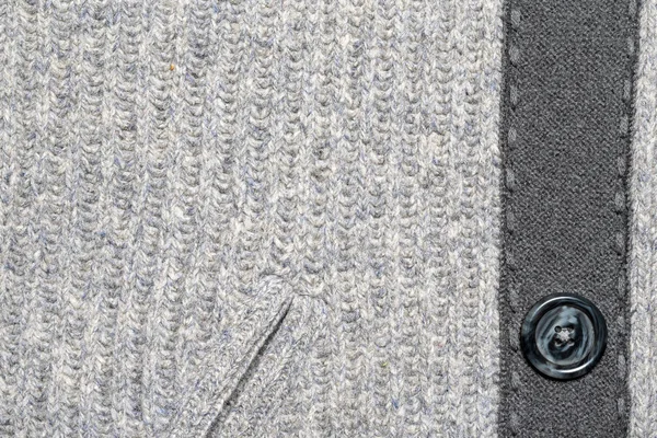 Fragment of knitted woolen clothes with a pocket and a button. S — Stockfoto