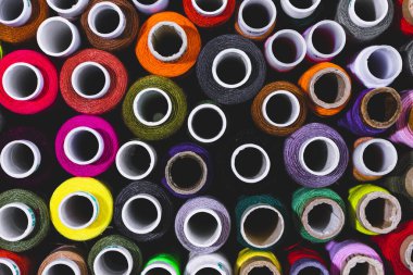 Colored spools of thread for sewing arranged in rows. Copy space.