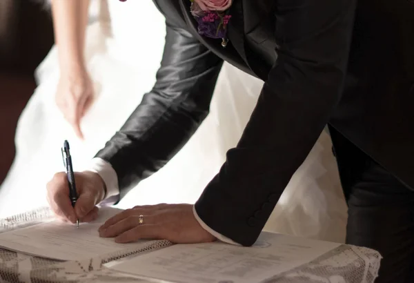 Wedding ceremony at church. Groom is leaving his signature. — Stock Photo, Image