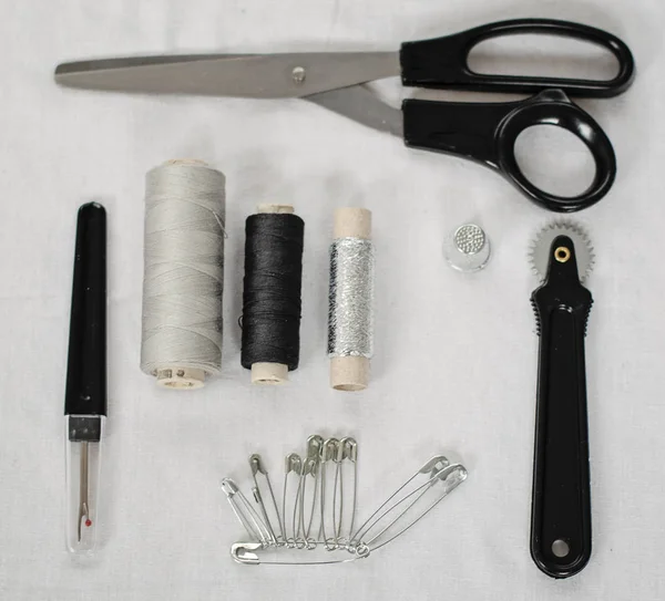 Sewing tools and accessories on white fabric — Stock Photo, Image