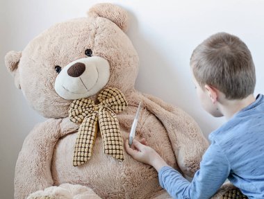 Anaokulu çocuğu hasta oyuncak ayısına bakıyor.. 