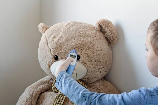 Junge kümmert sich um kranken Teddybär. — Stockfoto