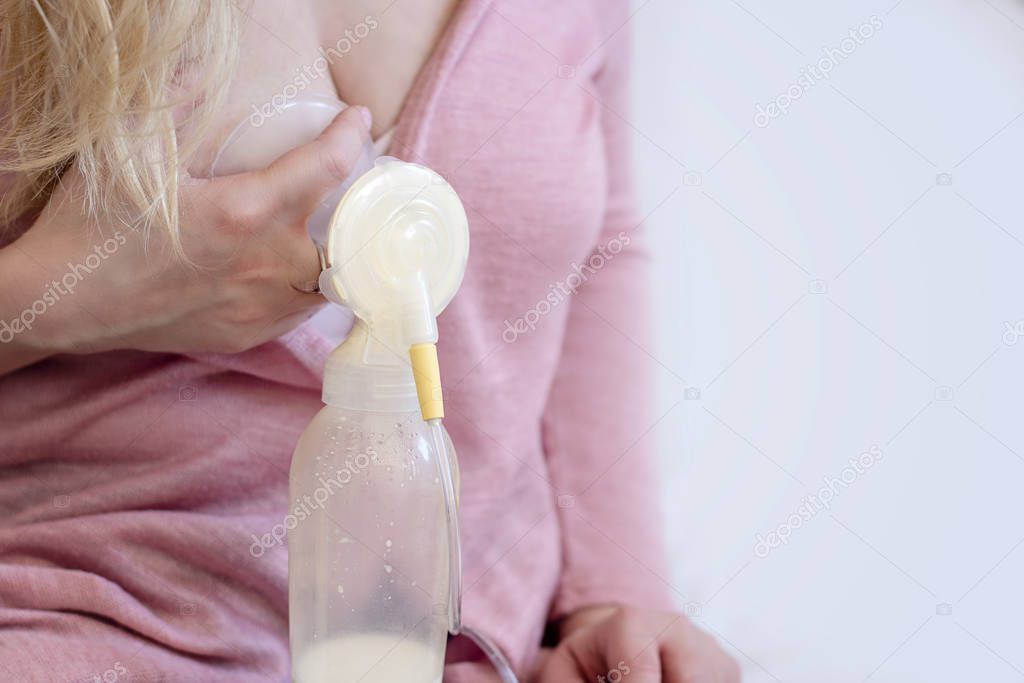 Young blonde mother is using single electric breast milk pump