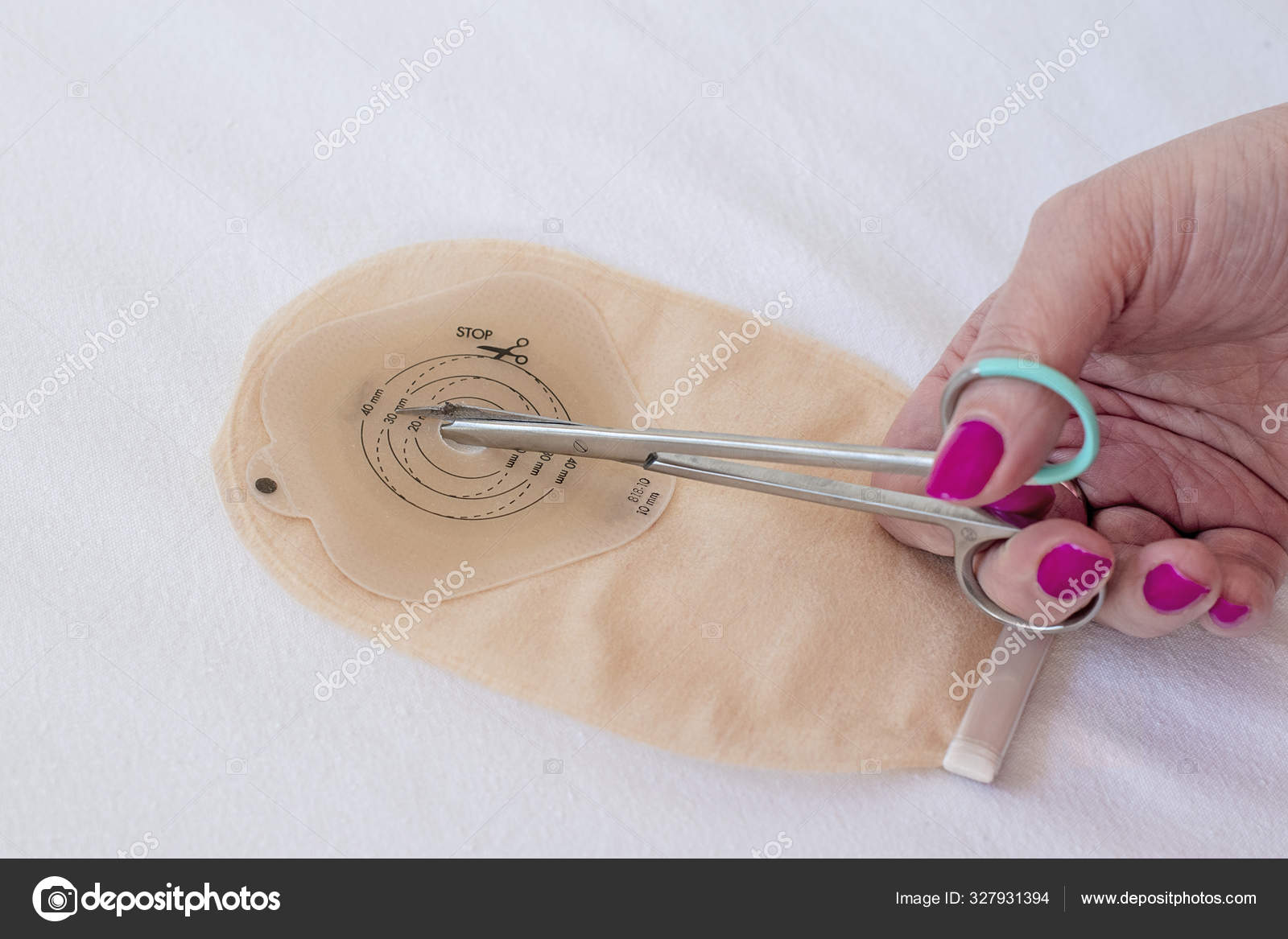 Top view on ostomy bag and scissors in female hand Stock Photo by