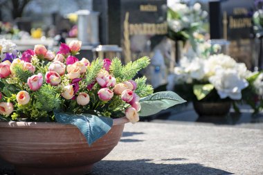 Güneşli bir günde mezarlık. Çiçekli ve mumlu mezarlar