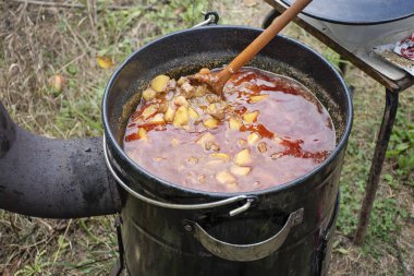Büyük bir kazanda lezzetli bir kebabı pişirmek. 